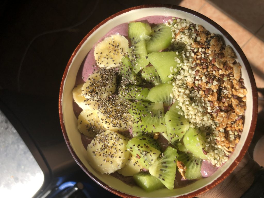 Protein Acai bowl topped with kiwi, banana, hemp seed, chia seed and granola fruits.